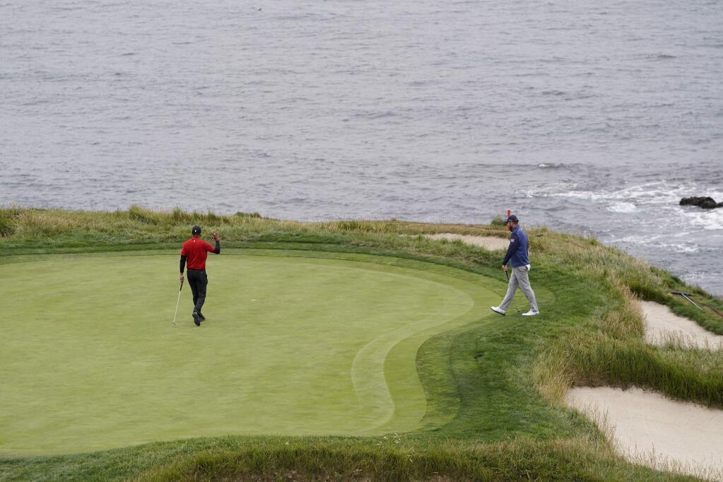 Tiger Woods, left, waves after birdie on the seventh hole and Marc Leishman, of Australia, looks on during the final round of the U.S. Open Championship golf tournament Sunday, June 16, 2019, in Pebble Beach, Calif. (AP Photo/David J. Phillip)
