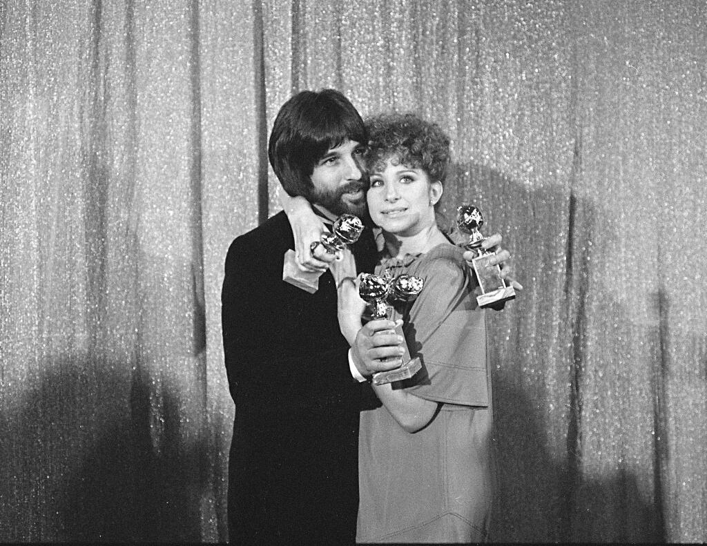 FILE - In this Jan. 29, 1977 file photo, Jon Peters and Barbra Streisand hold their awards at the Golden Globe Awards in Los Angeles. They won four awards for 'A Star Is Born.' Peters is a credited producer of the new 'A Star Is Born,' the third remake of the Hollywood fable. With the new film in the spotlight, Peters' history has come under scrutiny. Warner Bros. on Tuesday, Sept. 11, 2018, said the studio was contractually obligated to honor Peters as a producer. (AP Photo, File)
