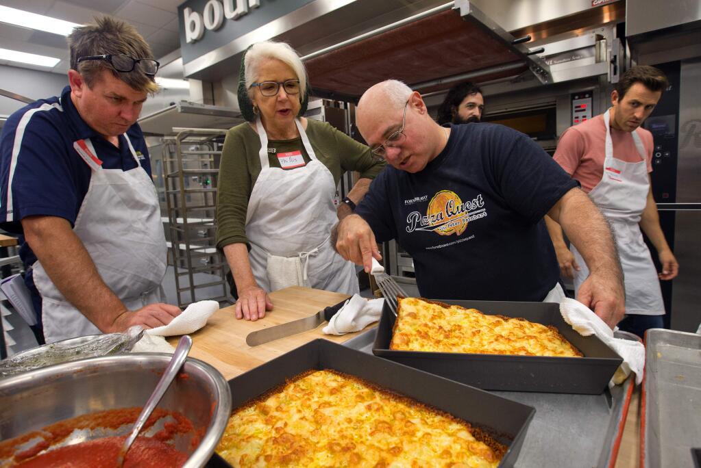 Bread and pizza baker/writer Peter Reinhart, second from right, checks the bottom for the perfect crispy crust on a Detroit-style Red-Stripe pan pizza during a class at the Artisan Baking Center at Keith Giusto Bakery Supply in Petaluma. (photo by John Burgess/The Press Democrat)