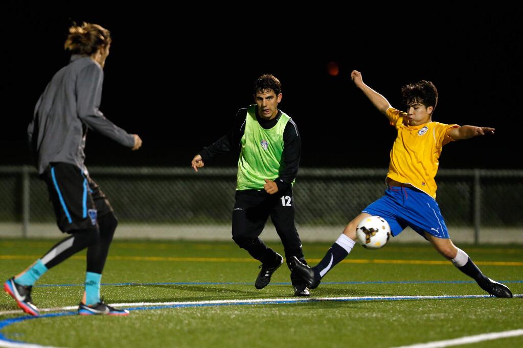 Michel Arroyo, right, keeps the ball in play while defended by Ebby Lombardi, center, during team practice for Sonoma County Sol FC in Petaluma, California on Thursday, February 25, 2016. (Alvin Jornada / The Press Democrat)