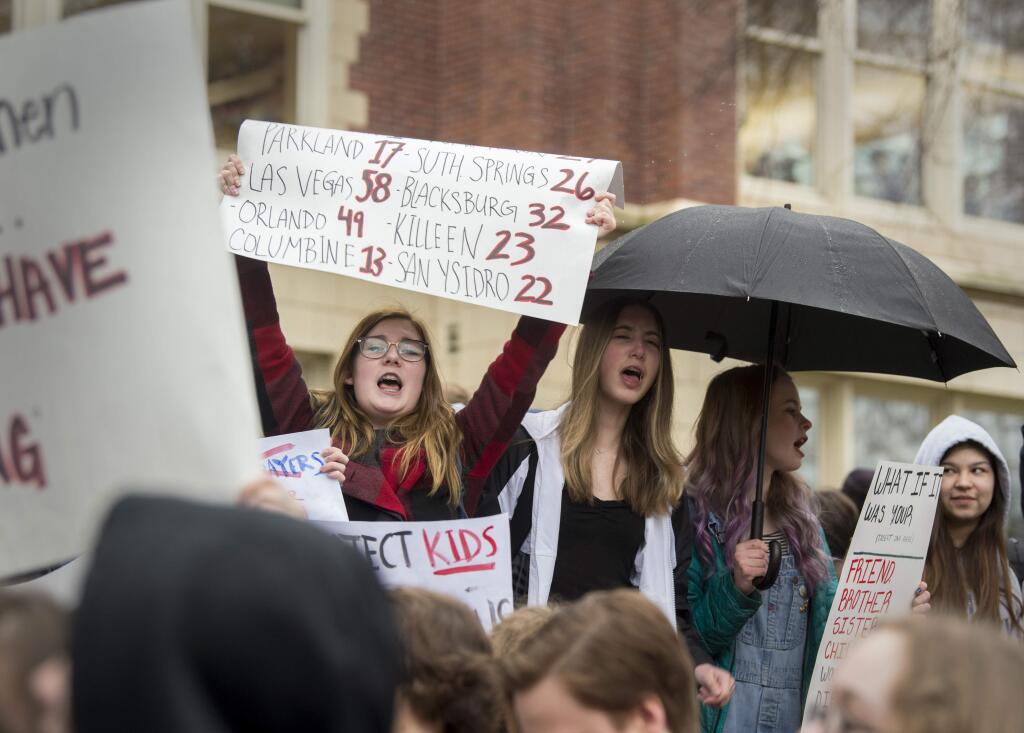 Abbey Kadlec, left, and her classmates stand on the stairs and sidewalk of Lewis and Clark High School to protest gun violence, part of a nationwide movement, Wednesday, March 14, 2018, in Spokane, Wash. Tens of thousands of students have walked out of their classrooms to demand action on gun violence and school safety. The demonstrations were some of the biggest by students in decades and extended from Maine to Hawaii as students joined the youth-led surge of activism set off by the Feb. 14 mass shooting at Marjory Stoneman Douglas High School in Parkland, Fla. (Jesse Tinsley/The Spokesman-Review via AP)