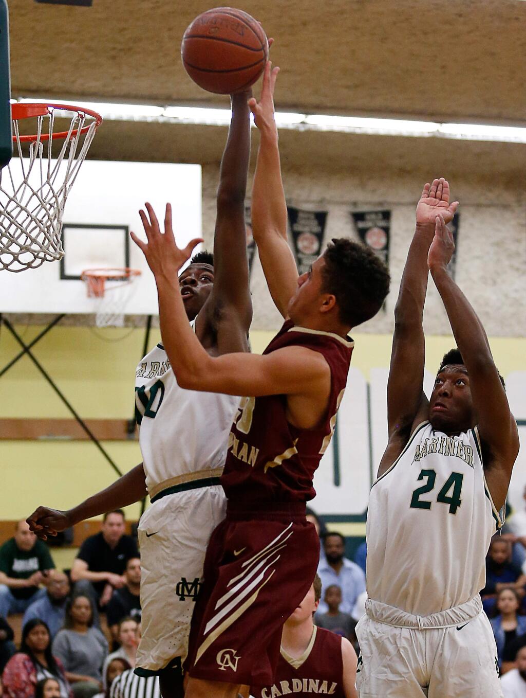 Cardinal Newman's Chauncey LeBerthon (20), center, gets blocked by Moreau Catholic's Leonard Turner (00), left, as he attempts a layup during the first half of the CIF Division II State boys basketball semifinal game between Cardinal Newman and Moreau Catholic high schools in Hayward, California on Tuesday, March 14, 2017. (Alvin Jornada / The Press Democrat)