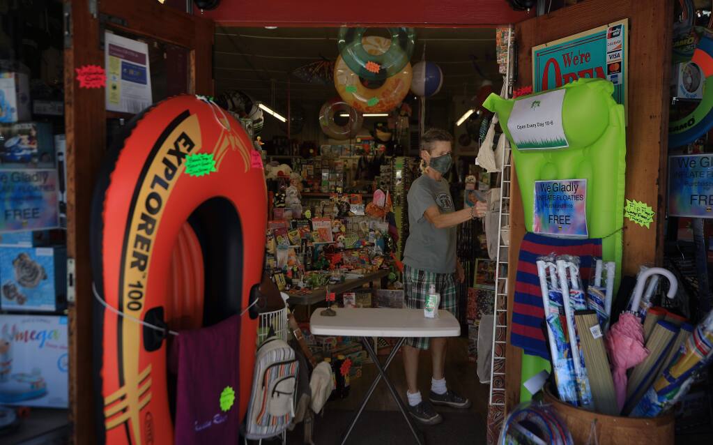 Guerneville 5 and 10's Robin Johnson straightens display items, Thursday, May 21, 2020 as Guerneville's business district gears up for Memorial Day. (Kent Porter / The Press Democrat) 2020