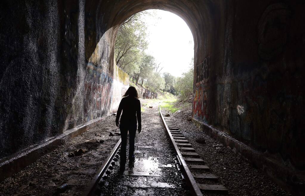 Caryl Hart, a North Coast Railroad Authority director, walks through a tunnel, in Cloverdale, where The Great Redwood Trail would travel along the rundown rail line from Larkspur to past Eureka, on Thursday, Feb. 7, 2019. (Christopher Chung / The Press Democrat)