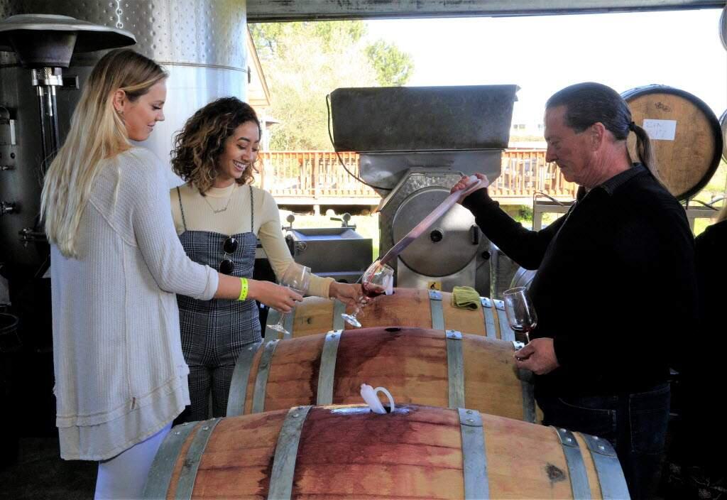 Rick Goodson, right, poured barrel samples for Masha Yelsukova, left, and Amira Dahdouh at Sunce winery on March 11, 2018. Celebrating 41 years, the Wine Road Barrel tasting weekends offer the opportunity to sample wines straight from the barrel, talk to winemakers and explore the beautiful Alexander, Dry Creek and Russian River Valleys. (Will Bucquoy/For the Press Democrat)