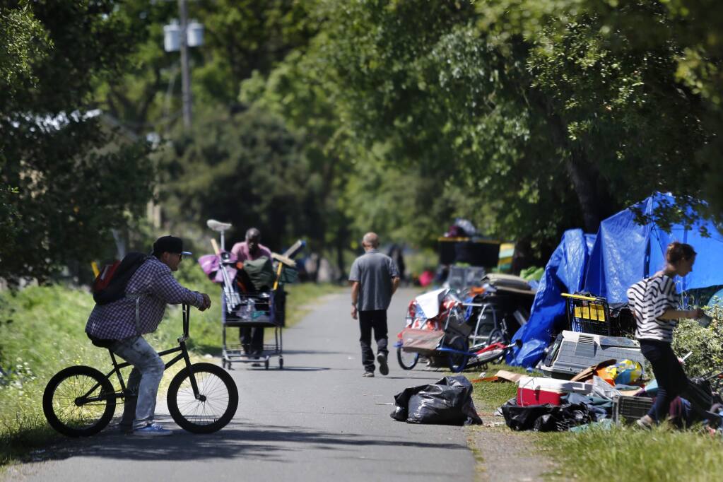 Members of the homeless community inhabit areas on either side of the Joe Rodota Trail next to the former Roseland homeless encampment in Santa Rosa on Thursday, April 19, 2018. (Beth Schlanker / The Press Democrat)