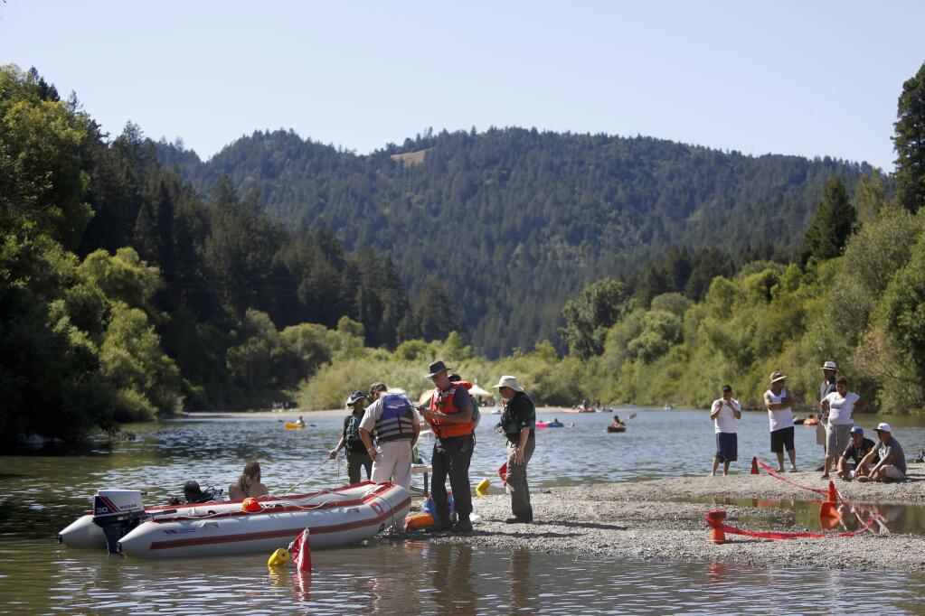 Members of the Sonoma County Sheriff's Office dive team and Monte Rio Fire Department search for the body of a missing man just downstream from Monte Rio Beach on Saturday, July 4, 2015. (BETH SCHLANKER / The Press Democrat)