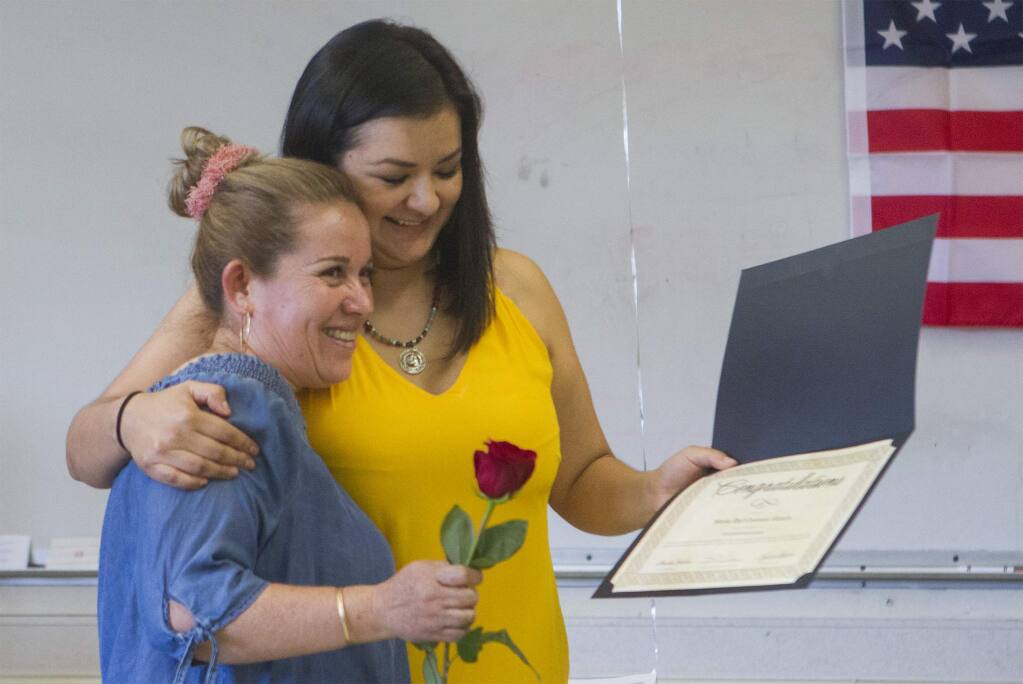 Betzy Chavez presents Carmen Garcia with an award certificate and a red rose. Sonoma Valley's newest U.S. citizens gathered at El Verano Elementary on Monday, June 25, for a celebration. (Photo by Robbi Pengelly/Index-Tribune)