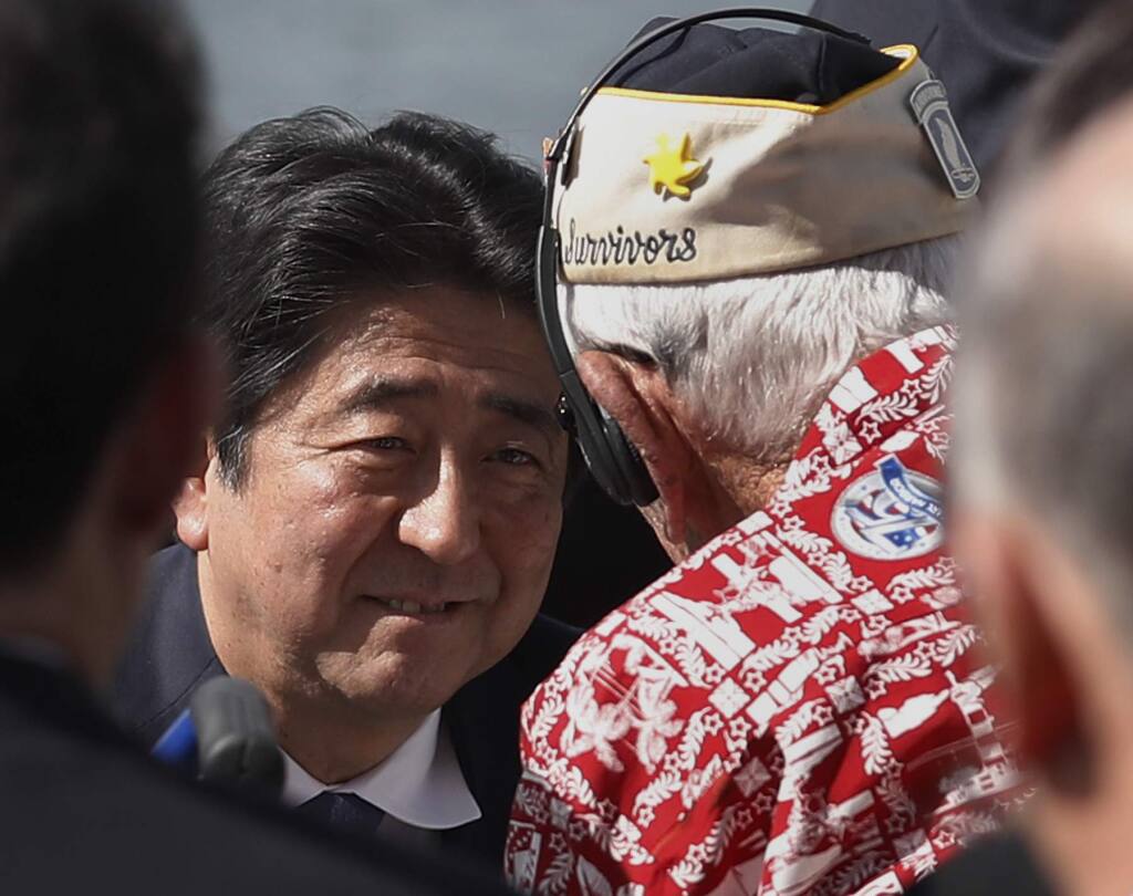 Japanese Prime Minister Shinzo Abe greets a Pearl Harbor survivor on Kilo Pier, overlooking the USS Arizona Memoria. (CAROLYN KASTER / Associated Press)