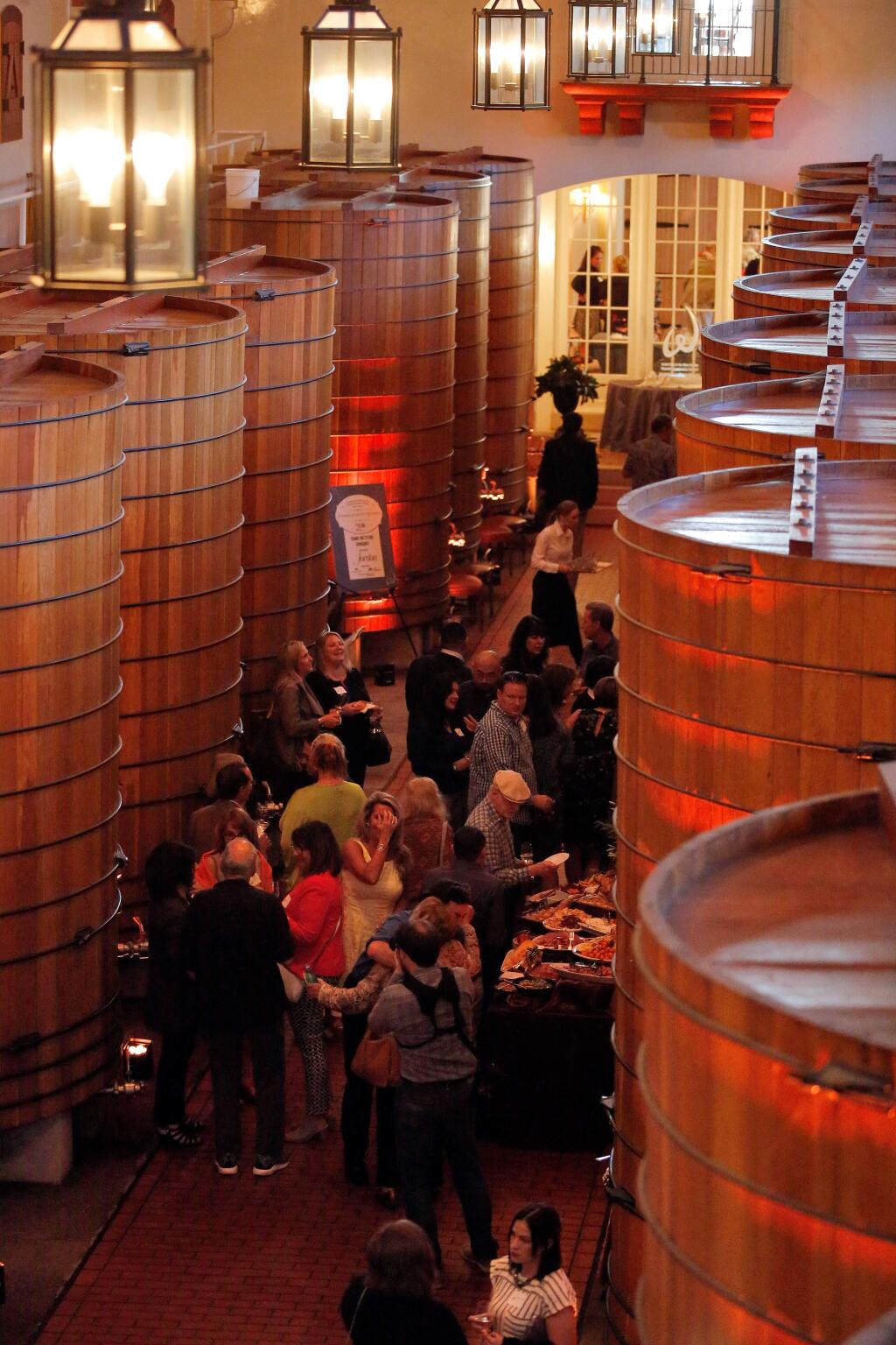 Guests enjoy wine, food and live music inside the Jordan Winery oak tank room during Reading Between the Vines, a fundraiser for United Way of the Wine Country's education initiatives, at Jordan Vineyard and Winery in Healdsburg, California, on Friday, March 31, 2017. (Alvin Jornada / The Press Democrat)