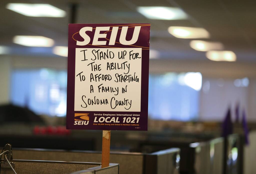 An SEIU sign sits atop a cubicle in the Economic Assistance division of the Sonoma County Human Services department's Mendocino Avenue office, in Santa Rosa on Monday, June 18, 2018. Sonoma County and the Service Employees International Union have reached a tentative one-year contract, which members will be voting on this week.(Christopher Chung/ The Press Democrat)