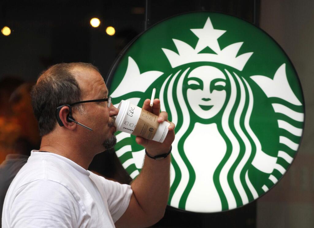 FILE - In this July 11, 2013 file photo, a man drinks a Starbucks coffee in New York. Starbucks says itís hiking prices again starting Tuesday, July 7, 2015, with the increases ranging from 5 to 20 cents for most affected drinks. (AP Photo/Mark Lennihan, File)