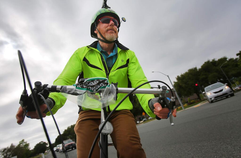 Sonoma Country Day School kindergarten teacher Steve Bush rides his bike home from work, along Airport Boulevard in Santa Rosa on Wednesday, May 10, 2017. Bush was named co-bike commuter of the year.(Christopher Chung/ The Press Democrat)