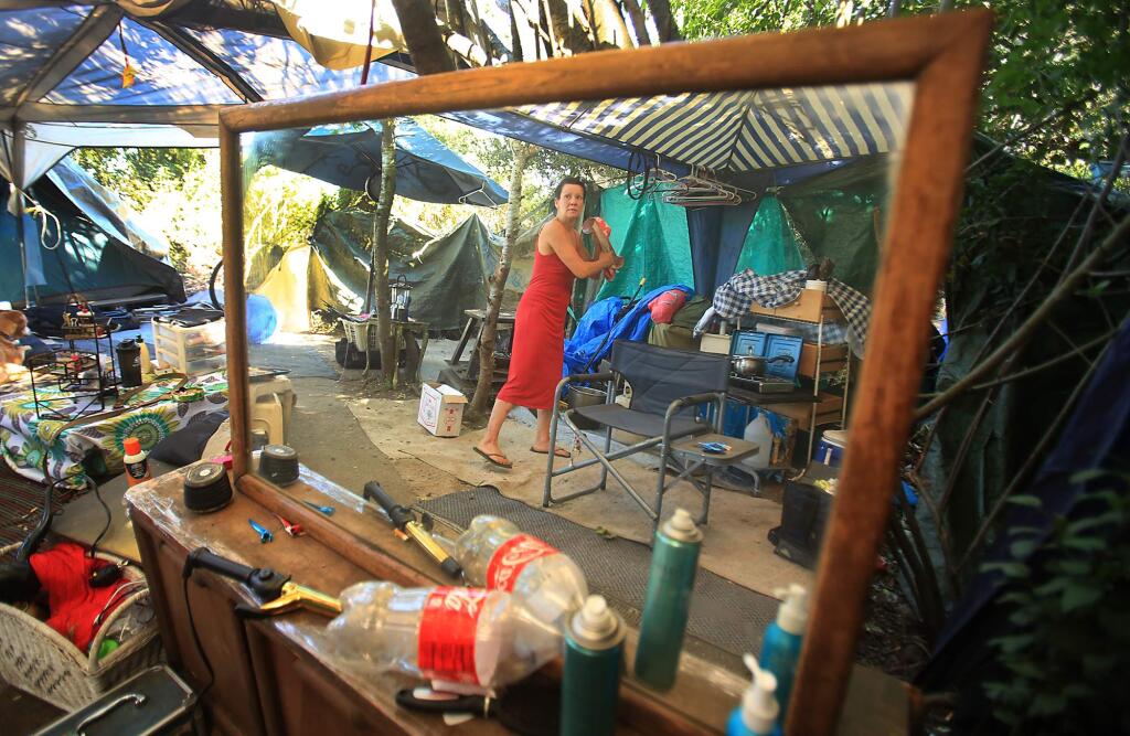 Capricia Moore cleans up her campsite on Homeless Hill off of Farmers Lane and Bennett Valley Road in Santa Rosa, Tuesday June 21, 2016 in Santa Rosa. (Kent Porter / Press Democrat) 2016