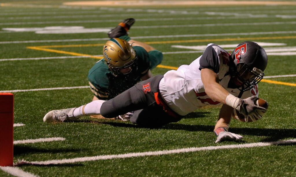 Redwood wide receiver Alex Wilson (12), right, successfully breaks the goal line plane to score a touchdown as he is tackled by Casa Grande outside linebacker Trevor Naugle (23) during the first half of an NCS Division 2 first round playoff game between Redwood and Casa Grande high schools in Petaluma, California on Friday, November 11, 2016. (Alvin Jornada / The Press Democrat)