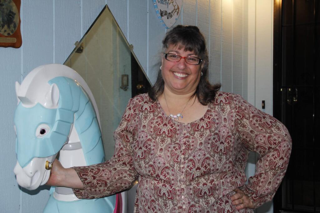 Windsor Performing Arts Academy director Heather Cullen poses with a prop from the play 'Mary Poppins.' The carousel horse has a temporary home on Cullen's front porch. (ANN CARRANZA)