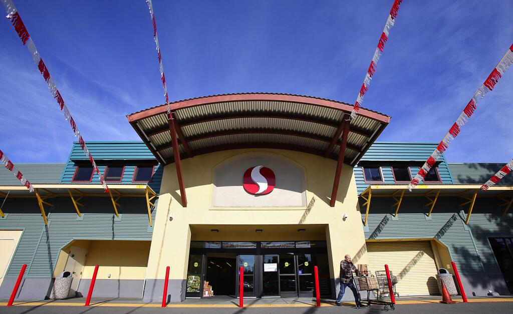 A shopper exits the new Safeway location along College Avenue in Santa Rosa, on Tuesday, December 20, 2016. (Christopher Chung/ The Press Democrat)