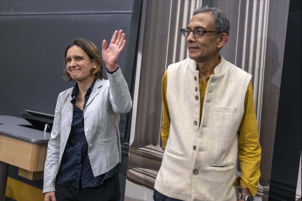 Esther Duflo, left, and Abhijit Banerjee stand together following a news conference at Massachusetts Institute of Technology in Cambridge, Mass., Monday, Oct. 14, 2019. Banerjee and Duflo, along with Harvard's Michael Kremer, were awarded the 2019 Nobel Prize in economics for pioneering new ways to alleviate global poverty. (AP Photo/Michael Dwyer)