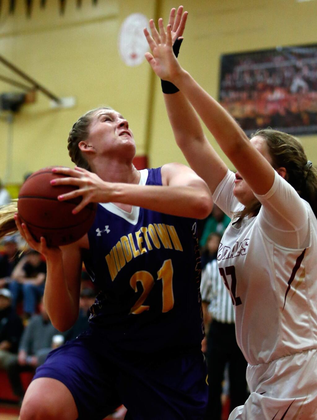 Middletown's Ashlyn Welton (21) drives to the basket while defended by Cardinal Newman's Taylor Hextrum (32) during the first half of the NCS Division 4 girls basketball quarterfinal game between Middletown and Cardinal Newman high schools in Santa Rosa, California, on Saturday, February 27, 2016. (Alvin Jornada / The Press Democrat)