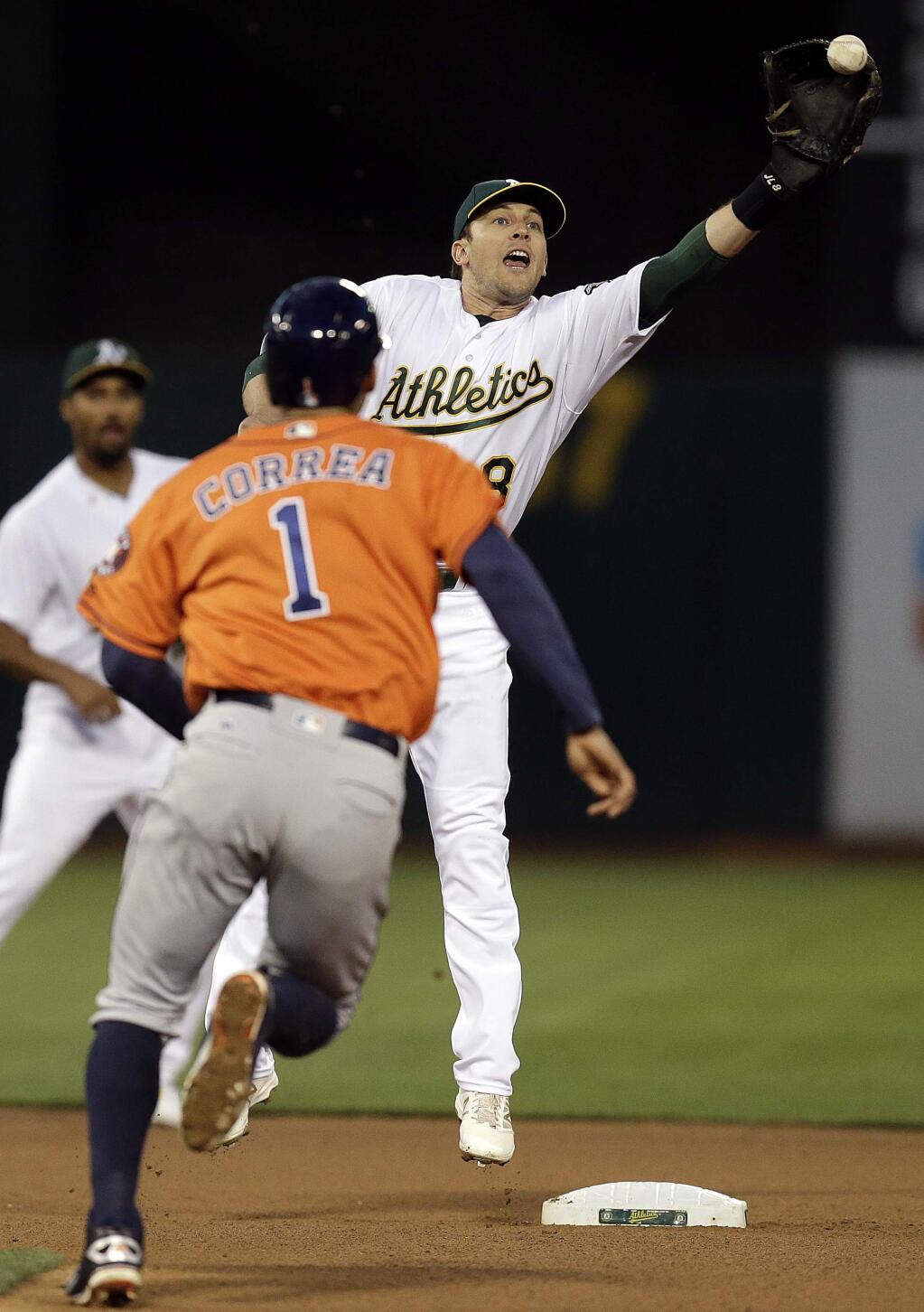 Oakland Athletics' Jed Lowrie, right, can't make the catch on the ball as Houston Astros' Carlos Correa (1) prepares to steal second base in the fourth inning of a baseball game Friday, April 29, 2016, in Oakland, Calif. (AP Photo/Ben Margot)