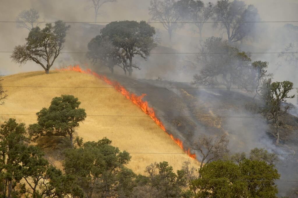 Fire burns the hillsides as the County fire continues near Lake Berryessa in Yolo County, California, Tuesday, July 3, 2018. (Randall Benton/The Sacramento Bee via AP)