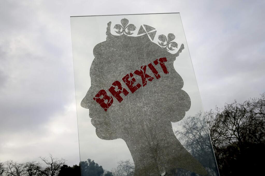 A view of a sculpture by London based Italian artist Matt Marga 'One Million Queen' which depicts a profile of Britain's Queen Elizabeth II in London, Monday, Dec. 10, 2018. The sculpture has been defaced with Brexit graffiti. (AP Photo/Tim Ireland)
