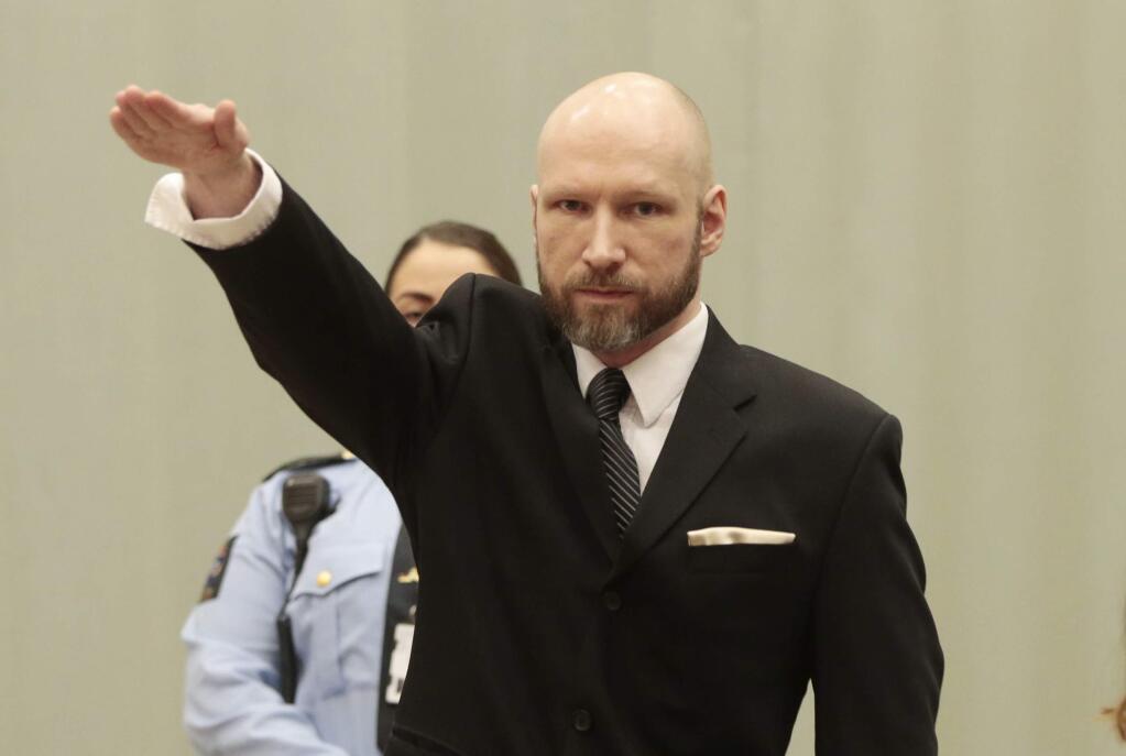 Anders Behring Breivik raises his right hand at the start of his appeal case in Borgarting Court of Appeal at Telemark prison in Skien, Norway, Tuesday, Jan. 10, 2017. Norwegian mass murderer Anders Behring Breivik walked quietly into a courtroom at a high security prison Tuesday, making a neo-Nazi salute, as judges began reviewing a government appeal against a ruling that his solitary confinement was inhumane and violated human rights. (Lise Aaserud/NTB Scanpix via AP)