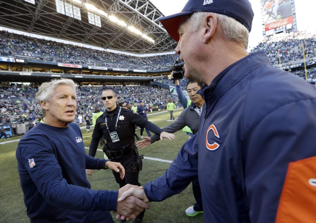 Seattle Seahawks head coach Pete Carroll, left, and Chicago Bears head coach John Fox, right, shake hands following an NFL football game, Sunday, Sept. 27, 2015, in Seattle. The Seahawks beat the Bears 26-0. (AP Photo/Elaine Thompson)