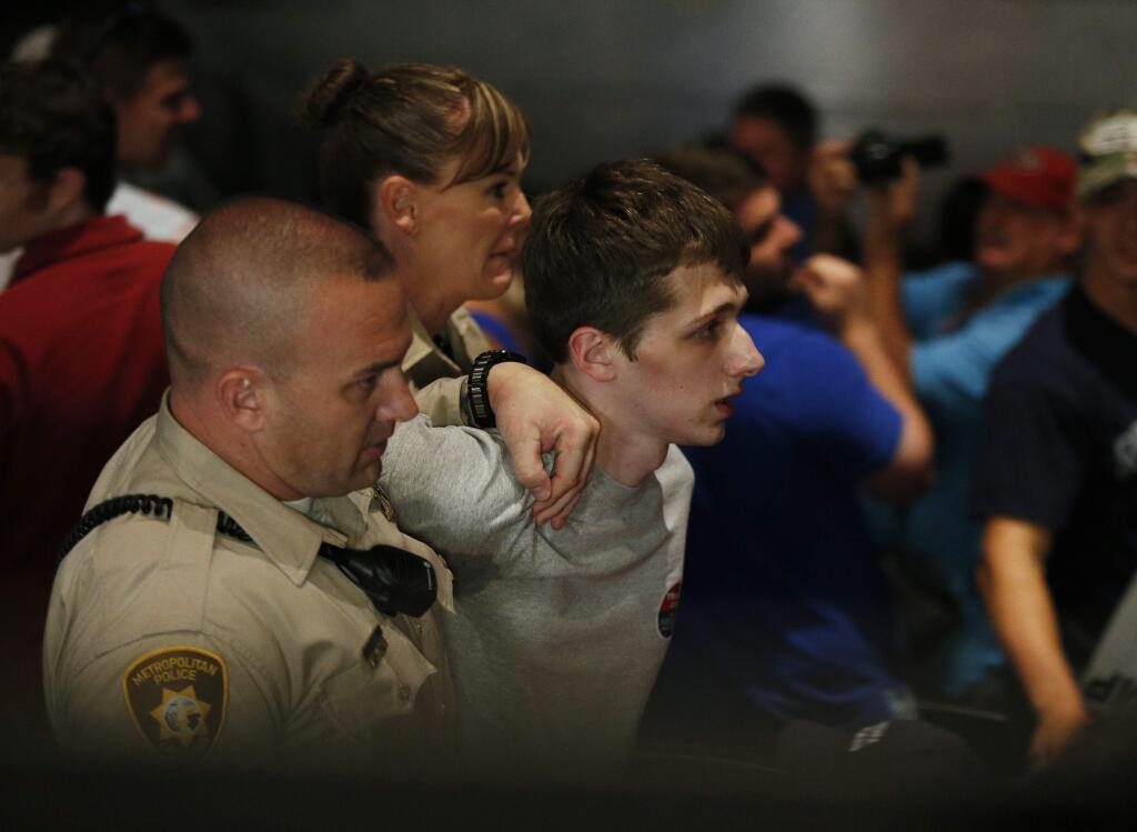 FILE - In this June 18, 2016, file photo, police remove protestor Michael Steven Sandford as Republican presidential candidate Donald Trump speaks at the Treasure Island hotel and casino in Las Vegas. Sandford, a British man accused of trying to take a police officer's gun and kill Donald Trump during a weekend rally in Las Vegas, will not be released on bail. Federal Magistrate Judge George Foley said at a hearing Monday that Sandford was a potential danger to the community and a flight risk. (AP Photo/John Locher, File)