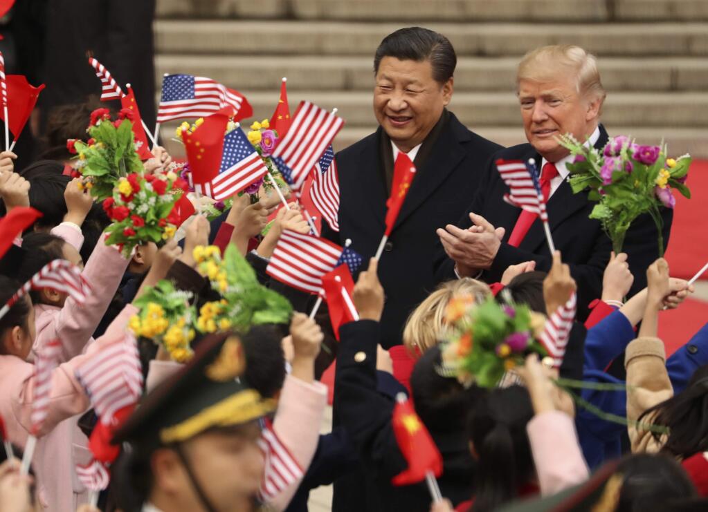 FILE - In this Nov. 9, 2017, file photo, President Donald Trump and Chinese President Xi Jinping participate in a welcome ceremony at the Great Hall of the People in Beijing, China. Trump couldn't seem to stop talking about the red carpets, military parades and fancy dinners that were lavished upon him during “state visits” on his recent tour of Asia. “Magnificent,” he declared at one point on the trip.But Trump has yet to reciprocate in kind. In fact, he is the first president in decades to close his first year in office without welcoming a counterpart on a visit to the U.S. with similar trappings. (AP Photo/Andrew Harnik, File)