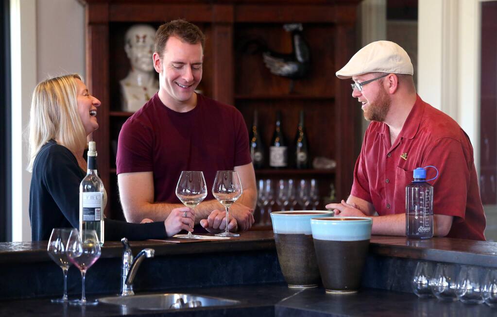 Raymond Rolander, right, owner of Wine Cube Tours, talks wines to clients Michael Krajewski and Vicki Roth, visiting from Oak Creek Wisconsin, in the tasting room of VML Winery, near Healdsburg on Tuesday, January 21, 2014. (Christopher Chung/ The Press Democrat)