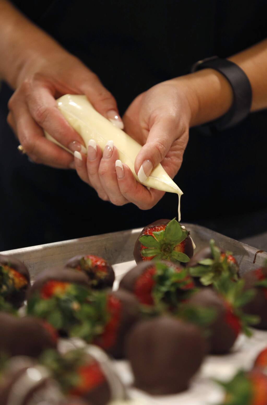 White chocolate is drizzled over chocolate covered strawberries during a spring brunch class at Ramekins on Sunday, April 17, 2016 in Sonoma, California. (BETH SCHLANKER/ The Press Democrat)