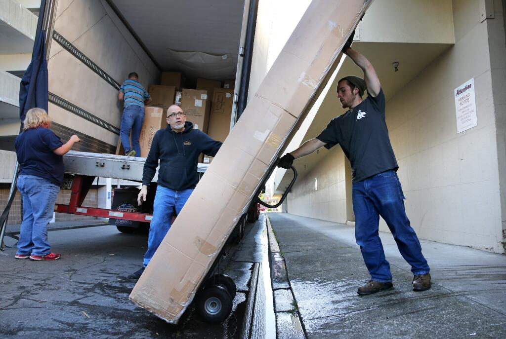 Assistant warehouse manager Aaron Navas, right, and his father, operations and service manager, Jim Navas, center, unload a shipment of furniture from North Carolina at the new Mark Thomas Home furniture store, formerly Pedersen's Furniture in Santa Rosa on Tuesday, April 9, 2019. (BETH SCHLANKER/ The Press Democrat)