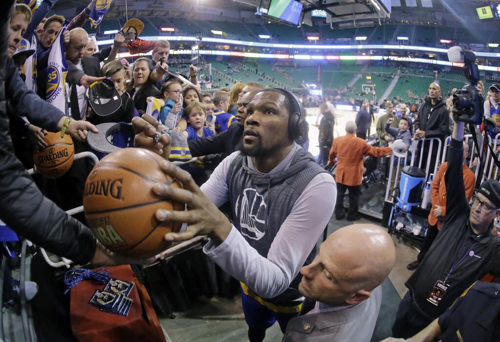 Golden State Warriors forward Kevin Durant signs autographs after working out before the start of their NBA basketball game against the Utah Jazz Thursday, Dec. 8, 2016, in Salt Lake City. (AP Photo/Rick Bowmer)