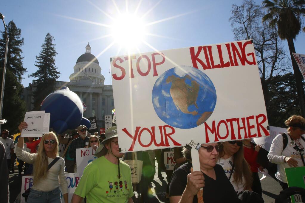 Protesters against oil drilling off the California Coast march from the state Capitol to a hearing by the U.S. Bureau of Ocean Energy Management, Thursday, Feb. 8, 2018, in Sacramento, Calif. It's the only public hearing in California on a Trump administration plan to propose six sales of drilling rights off the state's coast. (AP Photo/Rich Pedroncelli)