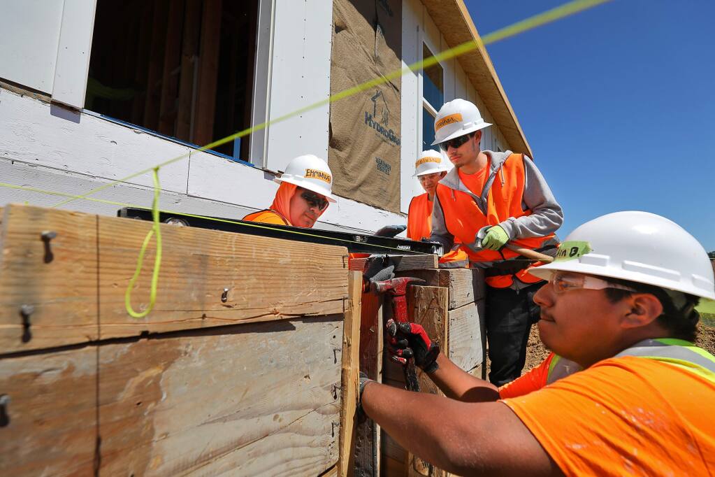 North Bay Construction Corps trainees Emmanuel Flores Lopez, left, Melvin Vasquez, Jonathan Figueroa, and Valentin Barrera work on building a prefabricated house for Habitat for Humanity, in Santa Rosa on Wednesday, June 19, 2019. (Christopher Chung/ The Press Democrat)