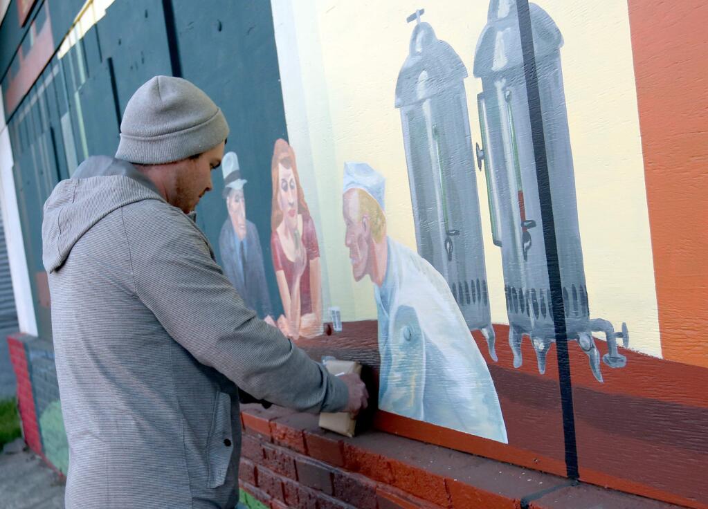Zack Rhodes hid his artwork next to a mural near the corner of College Avenue and Cleveland Avenue in Santa Rosa, Friday, March 6, 2015. Rhodes takes part in the 'Free Art Friday' movement where on Fridays artists hide their artwork and take a photo to post on instragram giving hints where the artwork can be found. (CRISTA JEREMIASON / The Press Democrat)