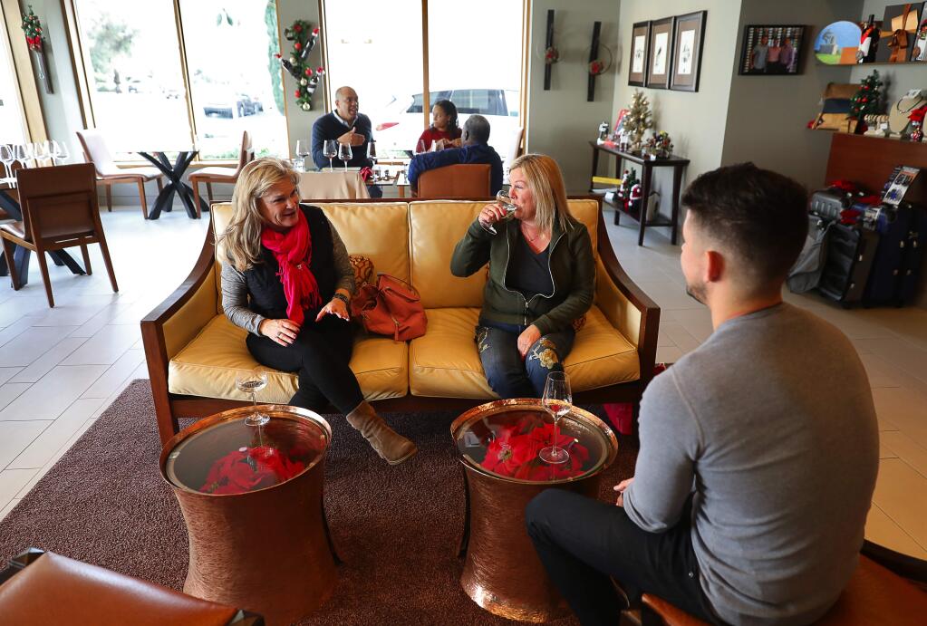 Tommi Hill, left, and Stephanie Van Cleave taste sparkling wine with general manager Brent Johnson at Corner 103 in Sonoma on Friday, December 15, 2017. (Christopher Chung/ The Press Democrat)