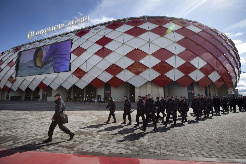 FILE - In this Saturday, Aug. 30, 2014 file photo police officers patrol before a friendly soccer match of Spartak soccer club veterans, in front of the Otkrytie Arena new stadium of Spartak Moscow soccer club in Moscow, Russia. Swiss federal prosecutors opened criminal proceedings related to the awarding of the 2018 and 2022 World Cups, throwing FIFA deeper into crisis only hours after seven soccer officials were arrested and 14 indicted Wednesday in a separate U.S. corruption probe. (AP Photo/Alexander Zemlianichenko, file)