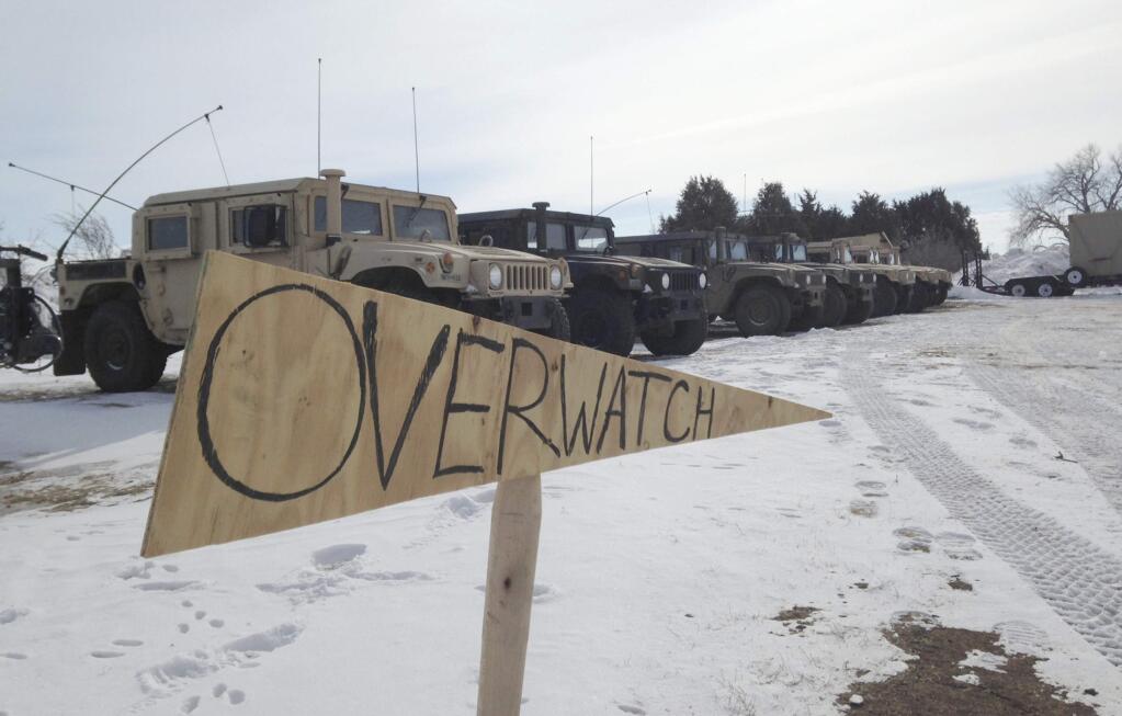Military vehicles are staged near the path of the Dakota Access pipeline Thursday, Feb. 9, 2017 near Cannon Ball, North Dakota. The developer says construction of the Dakota Access pipeline under a North Dakota reservoir has begun and that the full pipeline should be operational within three months. One of two tribes who say the pipeline threatens their water supply on Thursday filed a legal challenge asking a court to block construction while an earlier lawsuit against the pipeline proceeds. (AP Photo/James MacPherson)