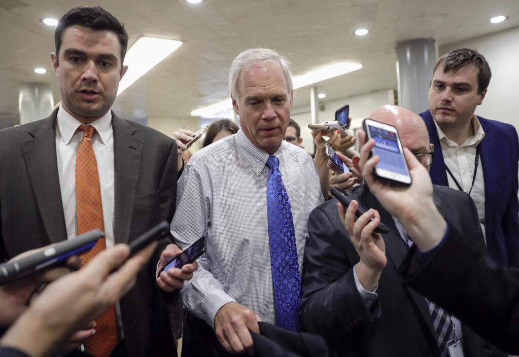 FILE - In this June 22, 2017, file photo, Sen. Ron Johnson, R-Wis., walks through a group of reporters after Republicans released their long-awaited bill to scuttle much of President Barack Obama's Affordable Care Act at the Capitol in Washington. Conservatives and liberals alike in Wisconsin both see hope in Johnson's steadfast refusal to back the current version of the GOP Senate health care bill. (AP Photo/J. Scott Applewhite, File)