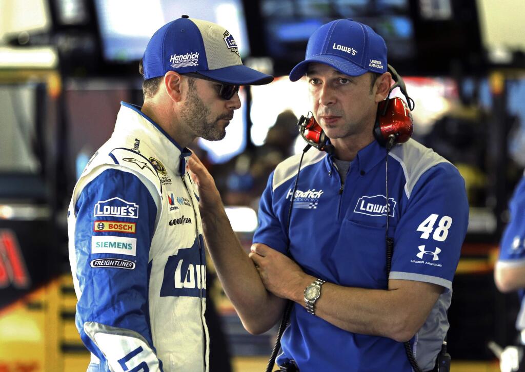 FILE - In this Feb. 12, 2016, file photo, Jimmie Johnson, left, talks with crew chief Chad Knaus in the garage during a practice session for a NASCAR auto race at Daytona International Speedway, in Daytona Beach, Fla. Seven-time championship winning crew chief Chad Knaus had his laptop stolen from a rental car in San Francisco, Wednesday, June 21, 2017, leaving him without the notes for Jimmie Johnson's NASCAR race this weekend at Sonoma .(AP Photo/Terry Renna, File)