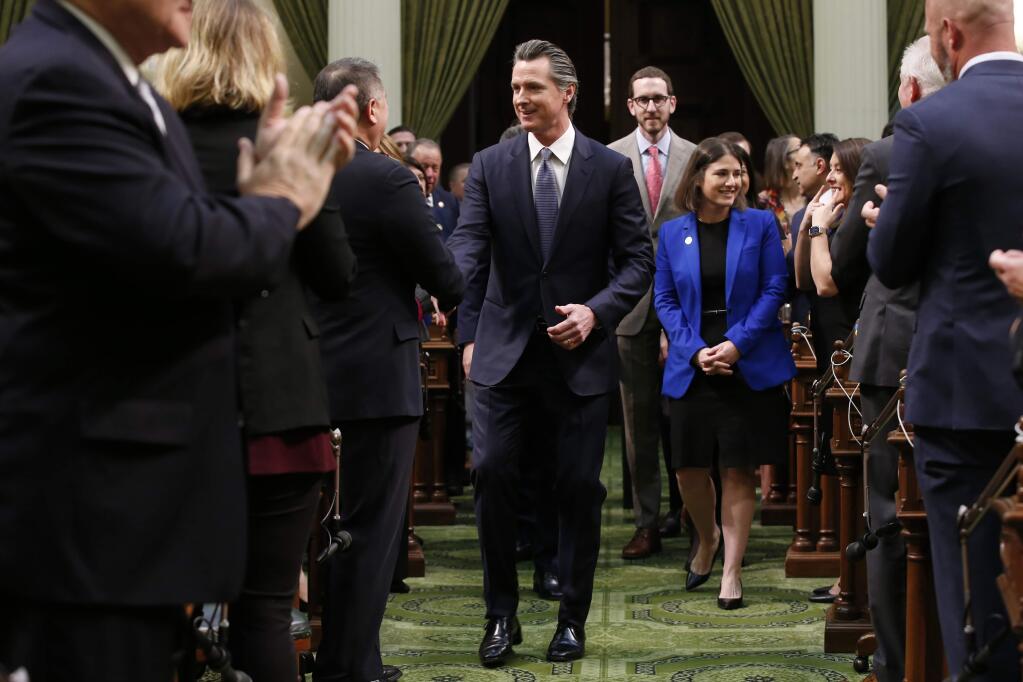 California Gov. Gavin Newsom is greeted by lawmakers as he enters the Assembly Chambers to give his State of the State address last week (RICH PEDRONCELLI / Associated Press)