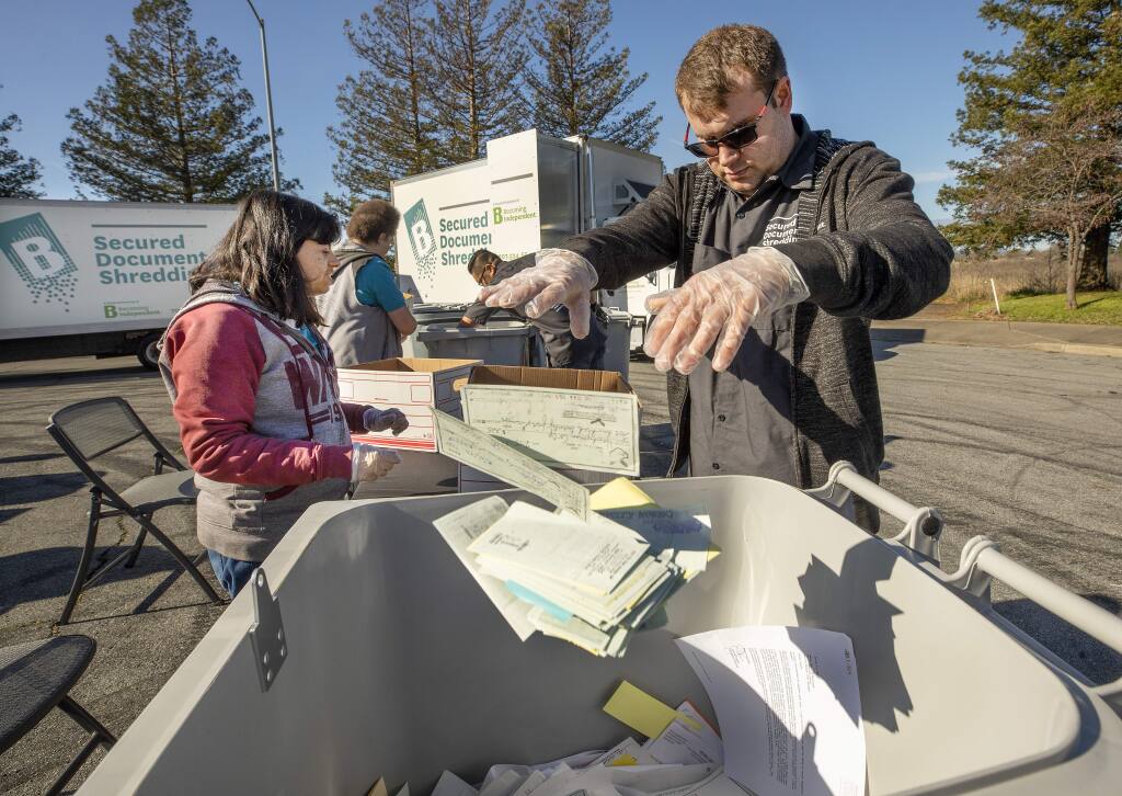 Betty Chavez, left, and Derek West remove paper clips, plastics and staples from documents before shredding them at Becoming Independent in Santa Rosa. Becoming Independent provides services for adults with developmental disabilities. (John Burgess/The Press Democrat)
