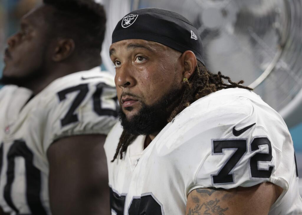 In this Nov. 5, 2017, file photo, Oakland Raiders offensive tackle Donald Penn sits on the sideline during the first half against the Miami Dolphins,in Miami Gardens, Fla. The Raiders cut ties with Penn on Saturday, March 16, 2019, after signing Trent Brown to the richest contract ever for a tackle earlier in the week and drafting two tackles in the first three rounds last year. (AP Photo/Lynne Sladky, File)