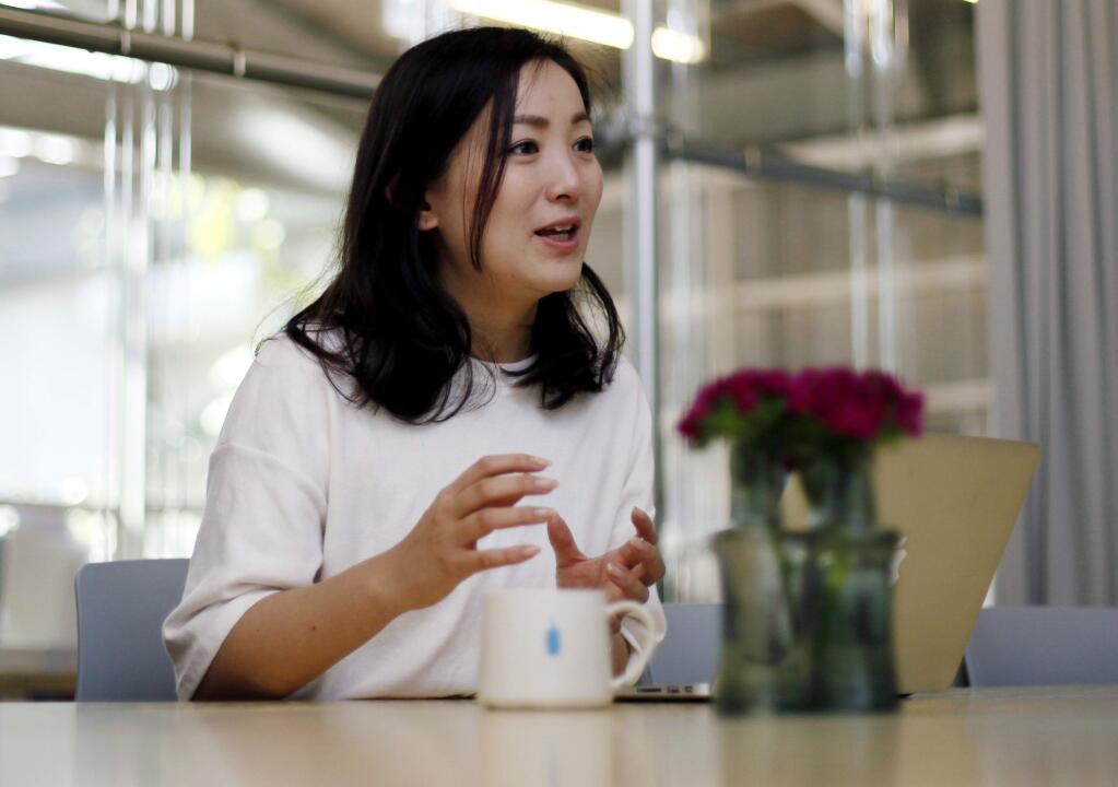 In this April 27, 2015 photo, Saki Igawa, business operations manager of Blue Bottle Coffee Inc., speaks during an interview at the coffee shop in Tokyo. Japan, famous for green tea, is welcoming artisanal American coffee roaster Blue Bottle with long lines that have at times meant a four-hour wait for a cup. We care about every part of the coffee. We call it from seed to cup, Igawa said. (AP Photo/Shuji Kajiyama)