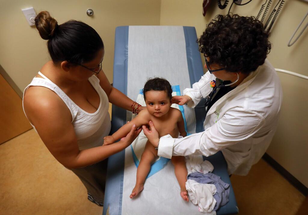 Dr. Danielle Oryn checks Kassandra Rodriquez, 8 months, with her mother Maria at the Petaluma Health Center on Thursday, June 16, 2017. (John Burgess/The Press Democrat)