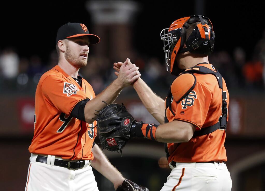San Francisco Giants starting pitcher Chris Stratton (34) in congratulated by catcher Nick Hundley (5) after a 2-0 victory against the Colorado Rockies in San Francisco, Friday, Sept. 14, 2018. (AP Photo/Tony Avelar)