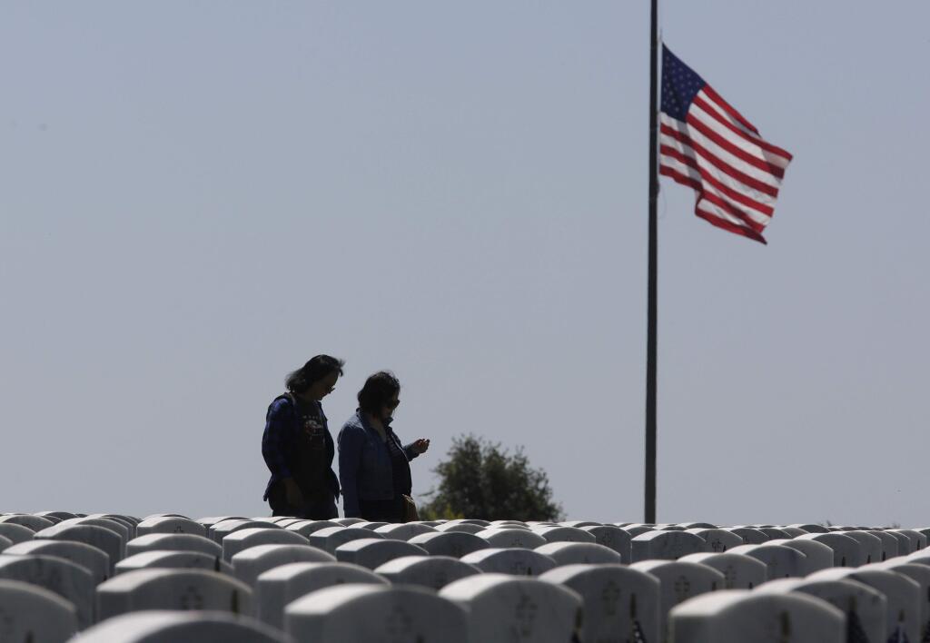 Visitors to the Sacramento Valley National Cemetery walk among the headstones, Monday, May 28, 2018, in Dixon, Calif. Californians across the state are paying their respects on Memorial Day to those who have died serving their country. (AP Photo/Rich Pedroncelli)