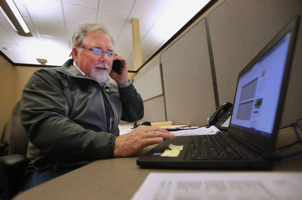 Tim Barger makes a call on his smartphone in his office at Nordby Construction, in Santa Rosa, on Friday, March 11, 2016. Barger, who uses AT&T, finds his cellular service spotty North Dutton Avenue office, as well as at his home in the west county.(Christopher Chung/ The Press Democrat)